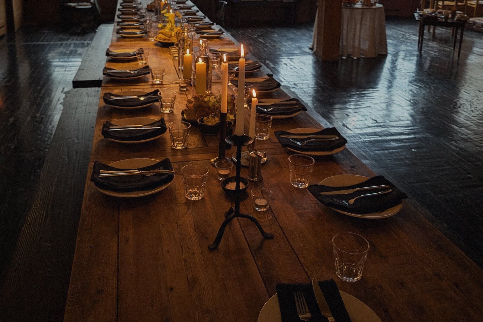 A long candlelit table set for dinner
